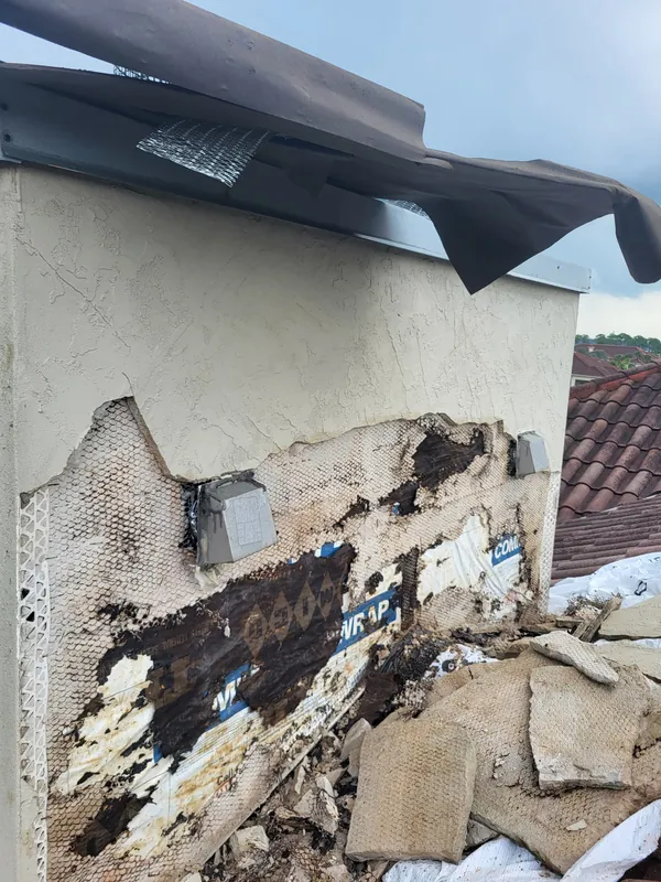Chimney before: failed stucco removed, exposing water damage
