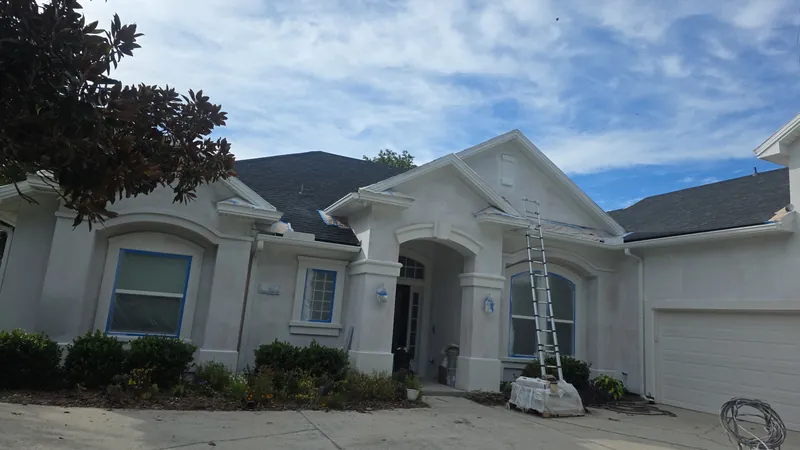 Single-story stucco home during an exterior repaint